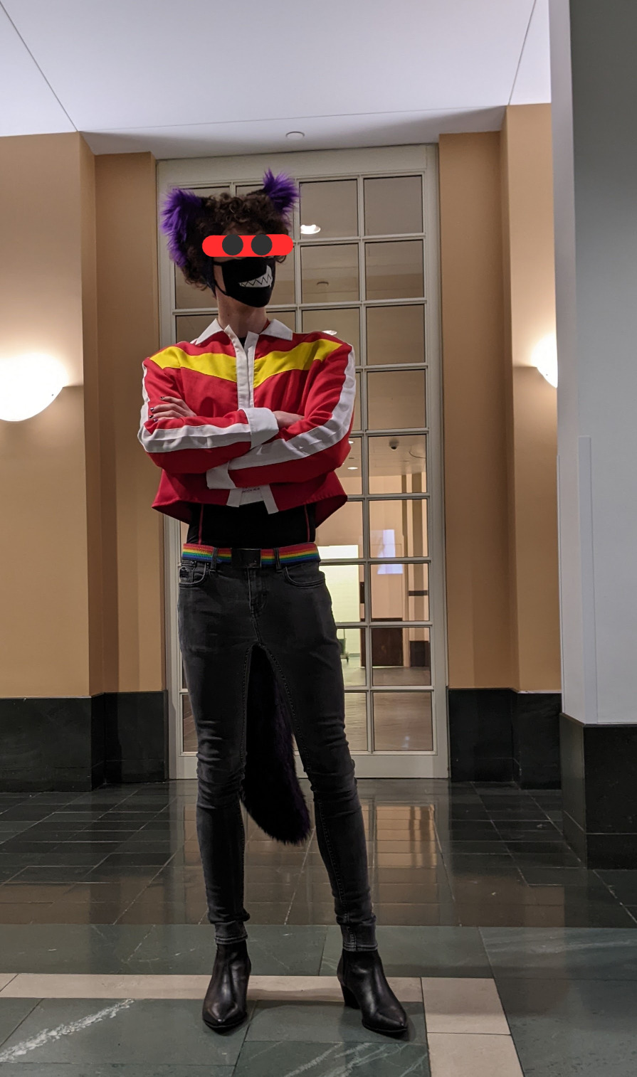 Myself posing in a contrapposto position wearing a mid-quality replica of Voltron:Legandary Defender Keith Kogane's jacket with my matching purple and black tail and ears, also with black skinny jeans and some heeled boots